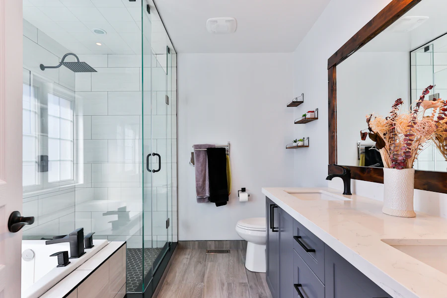 Glass walk-in shower enclosure with a rainfall head next to a double vanity